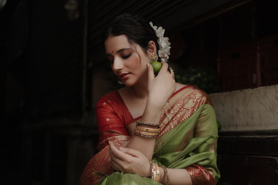 Stylish woman in a vibrant saree with gold jewelry, embracing her culture.
